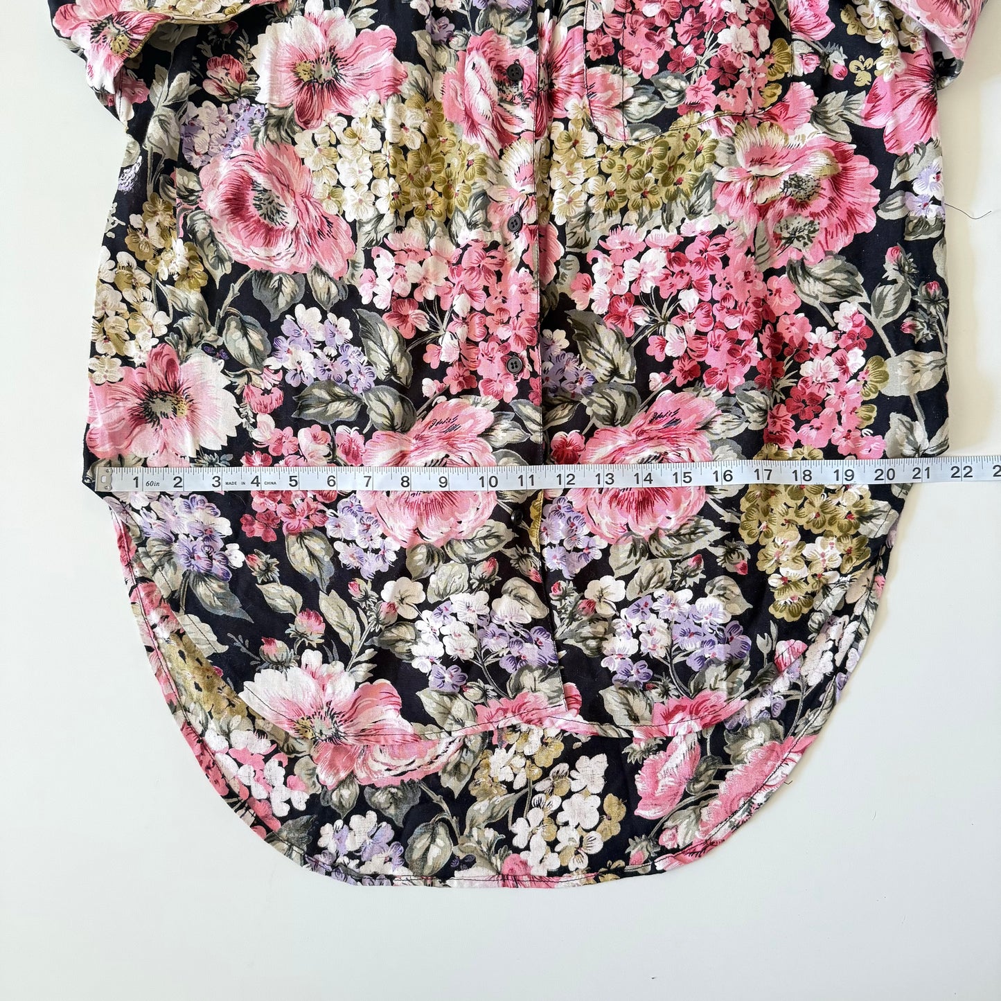 Floral-patterned fabric with a measuring tape indicating dimensions on a white background