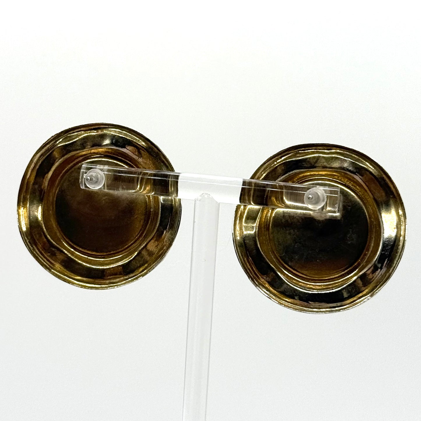 Pair of gold earrings with clear stones on a white background
