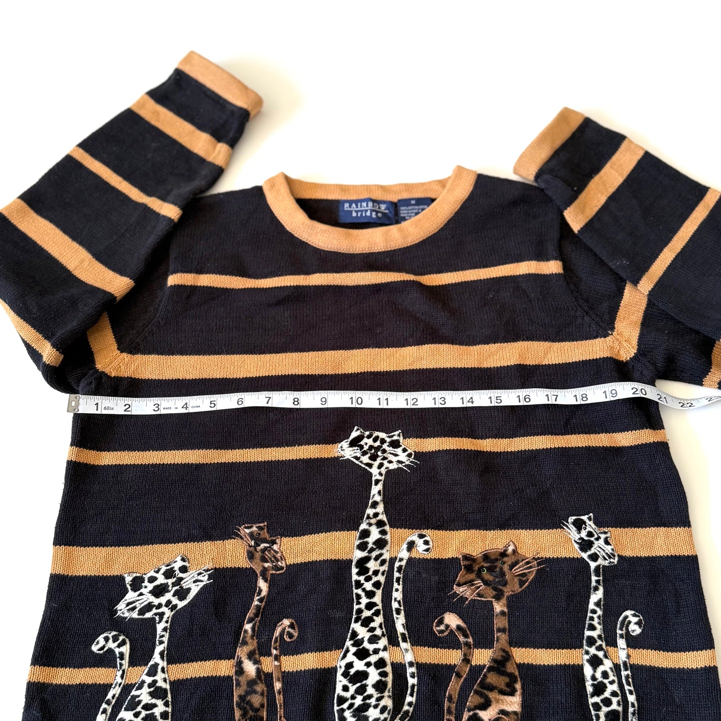 Navy and beige striped sweater with animal prints on a white background