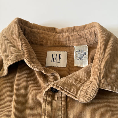 Close-up of a brown corduroy shirt with a GAP label on a white background