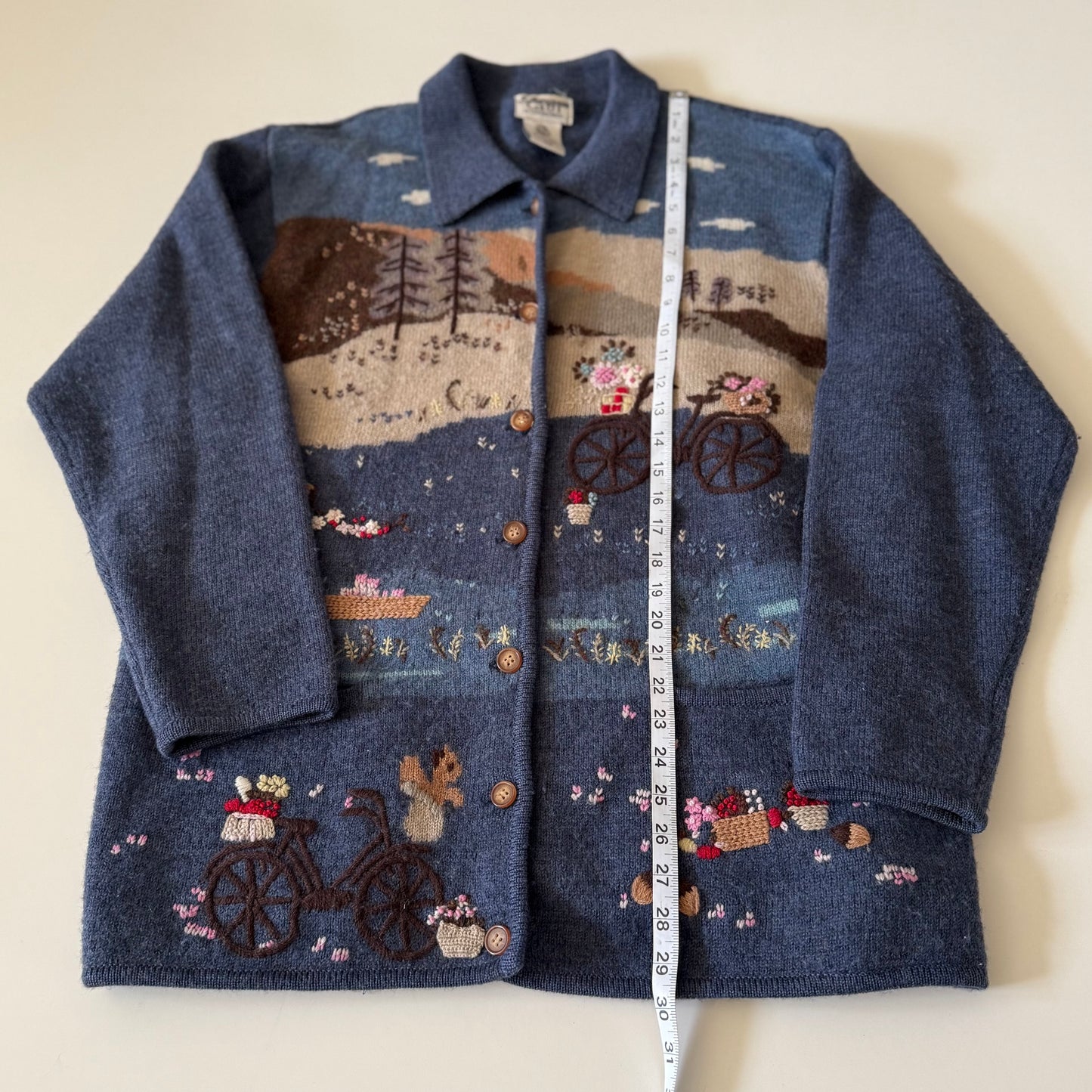 Blue jacket with embroidered designs on a white background