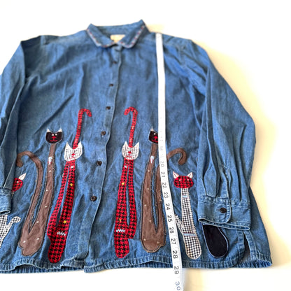 Denim shirt with cat appliqués on a white background