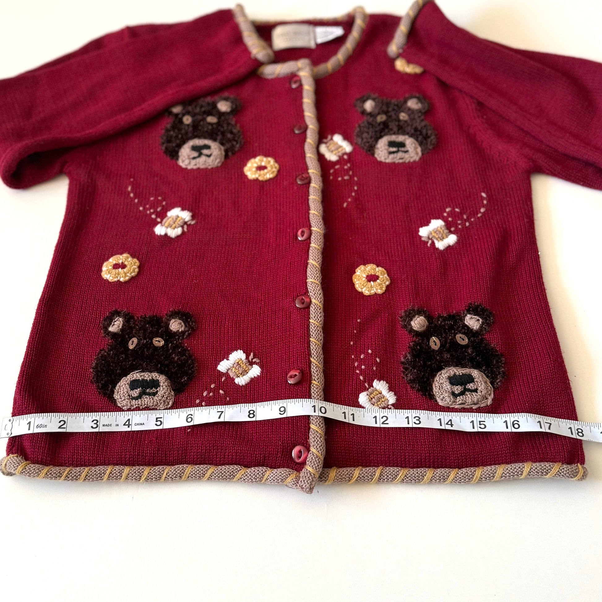 Bear cardigan with measuring tape on it. 