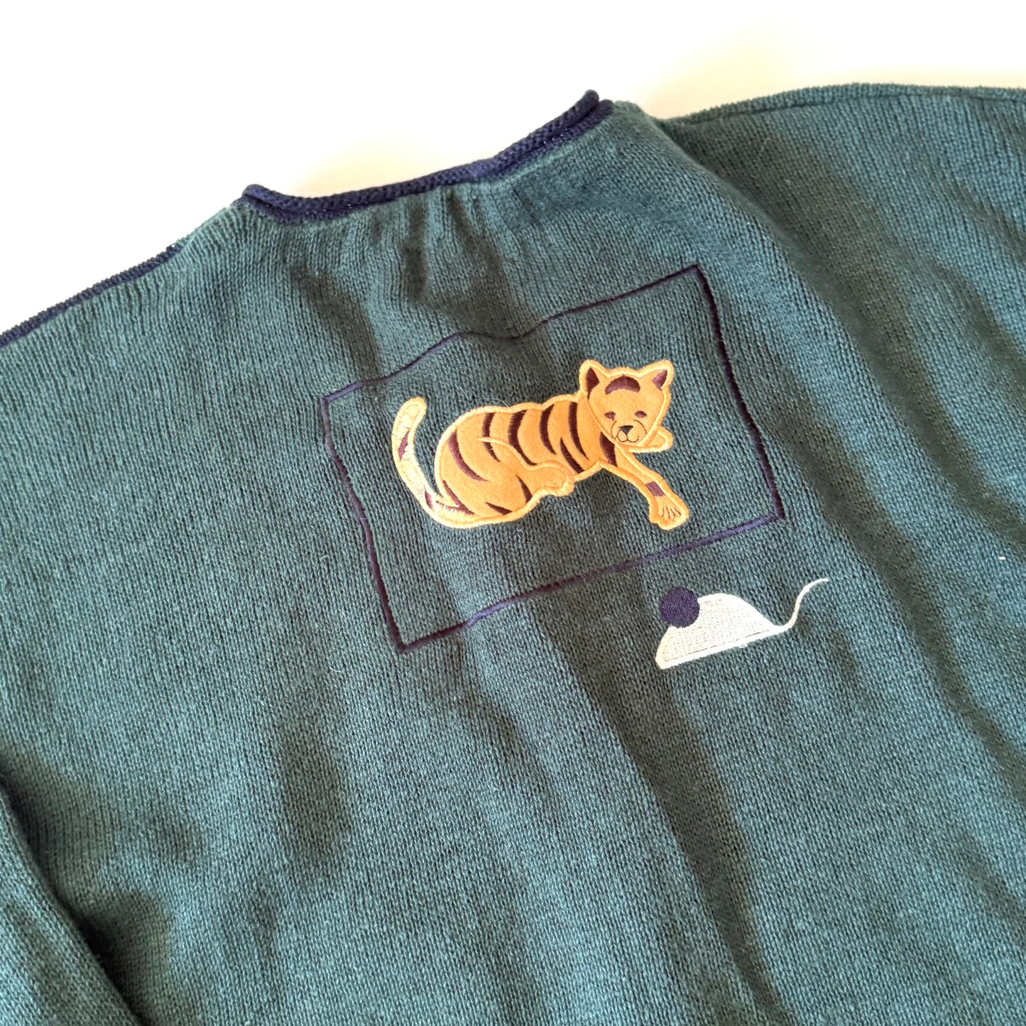 Green sweater with a tiger patch on a white background