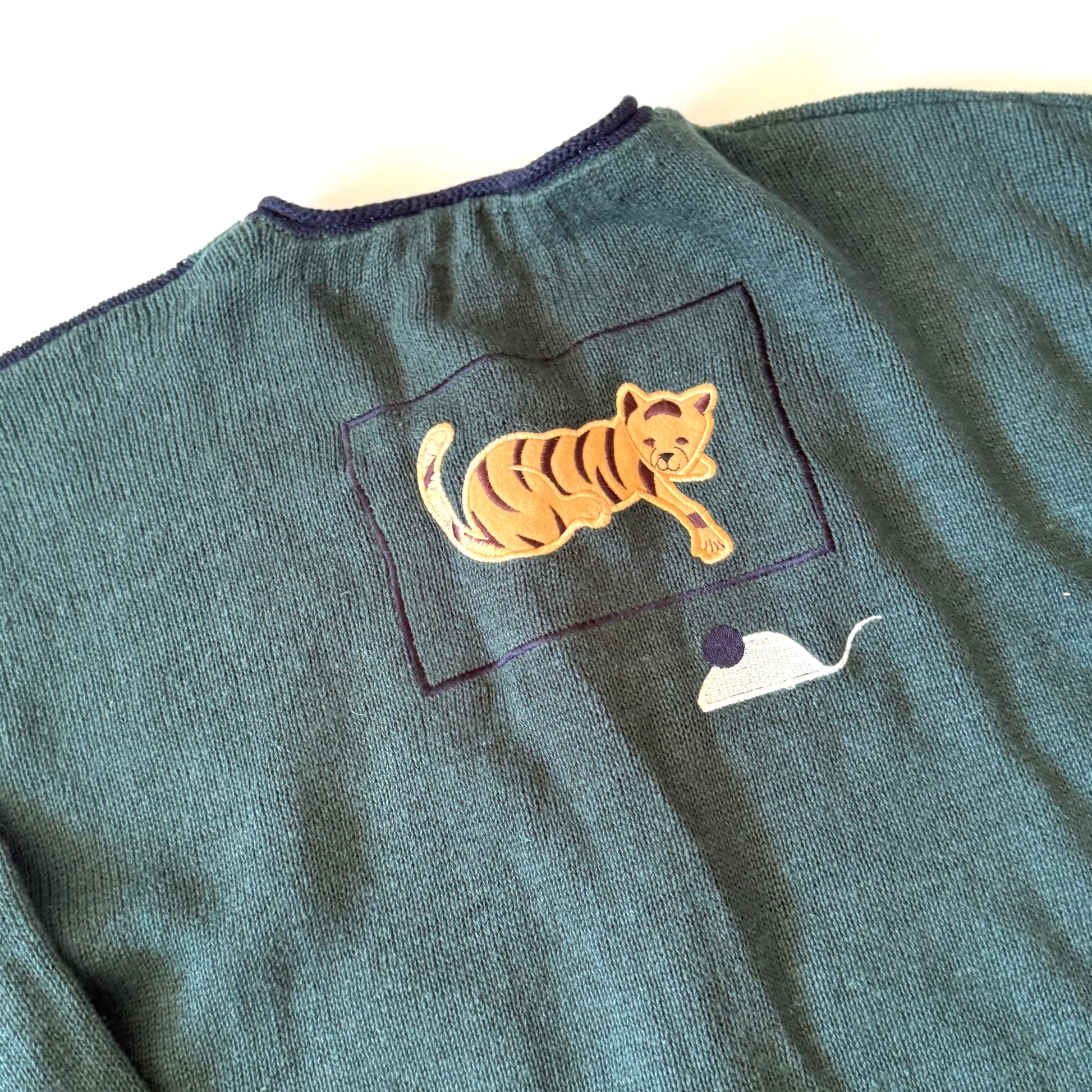 Green sweater with a tiger patch on a white background