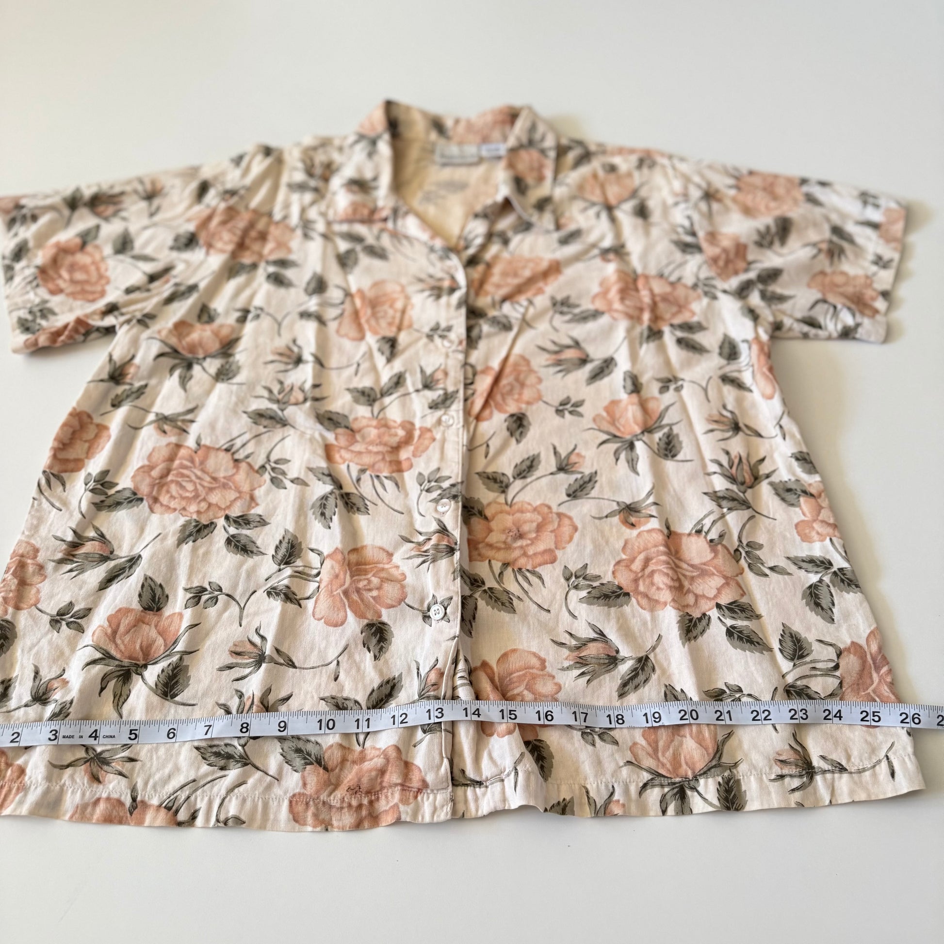 Floral-patterned garment with a measuring tape for size reference on a white background