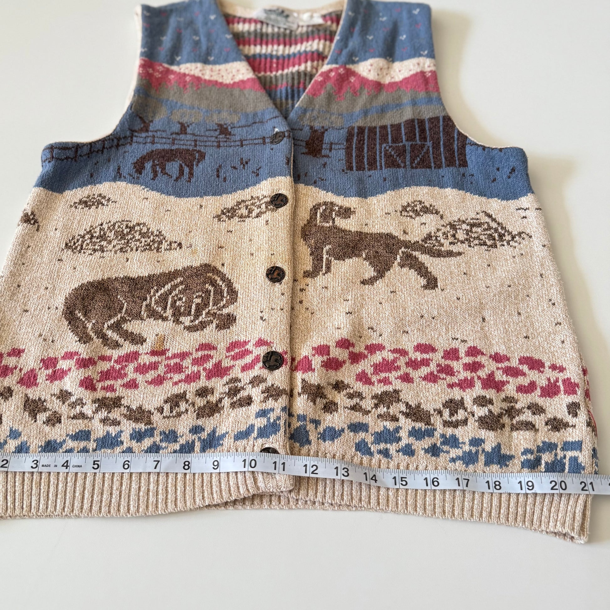 Knitted vest with animal pattern and measuring tape for size reference