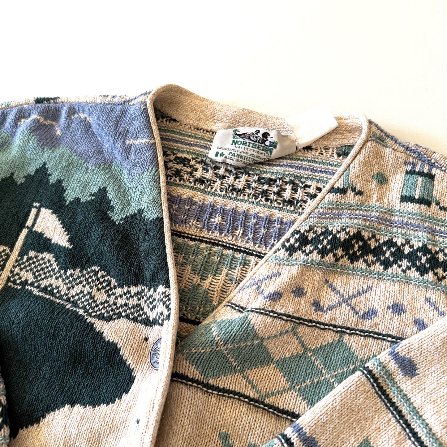 Tag of the cardigan with white backdrop at top.