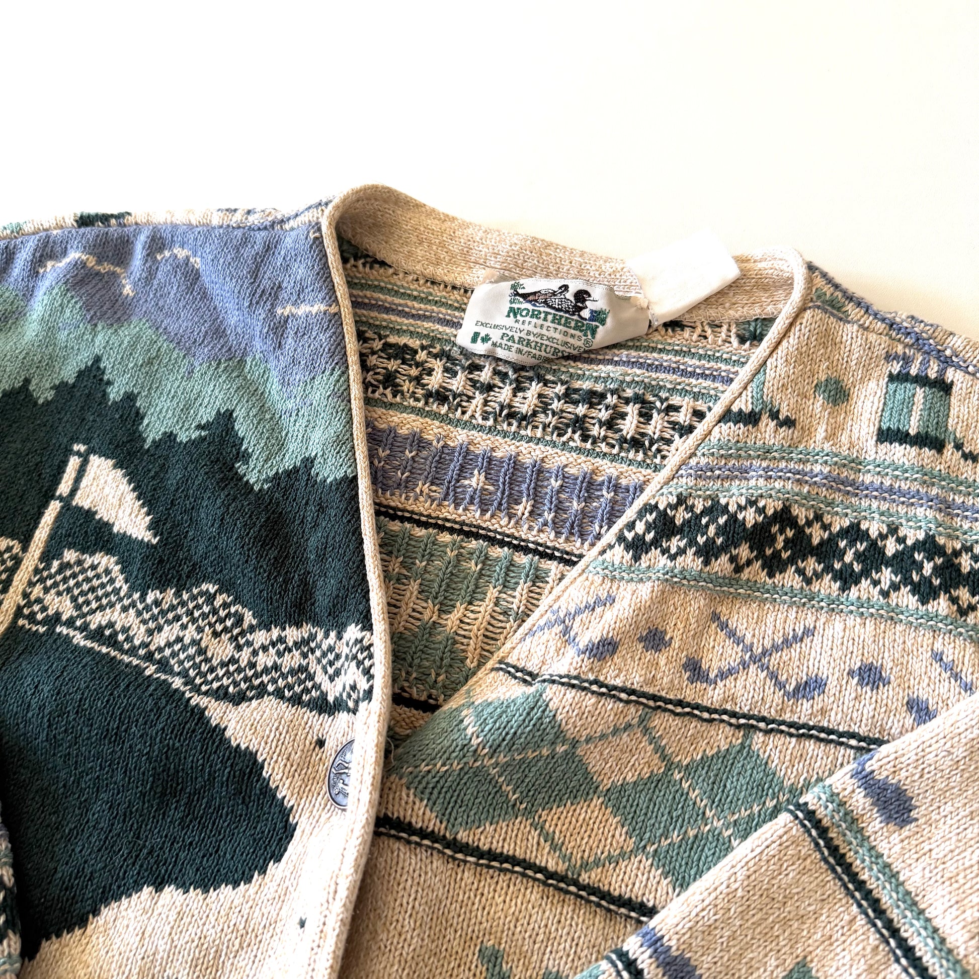 Tag of the cardigan with white backdrop at top.