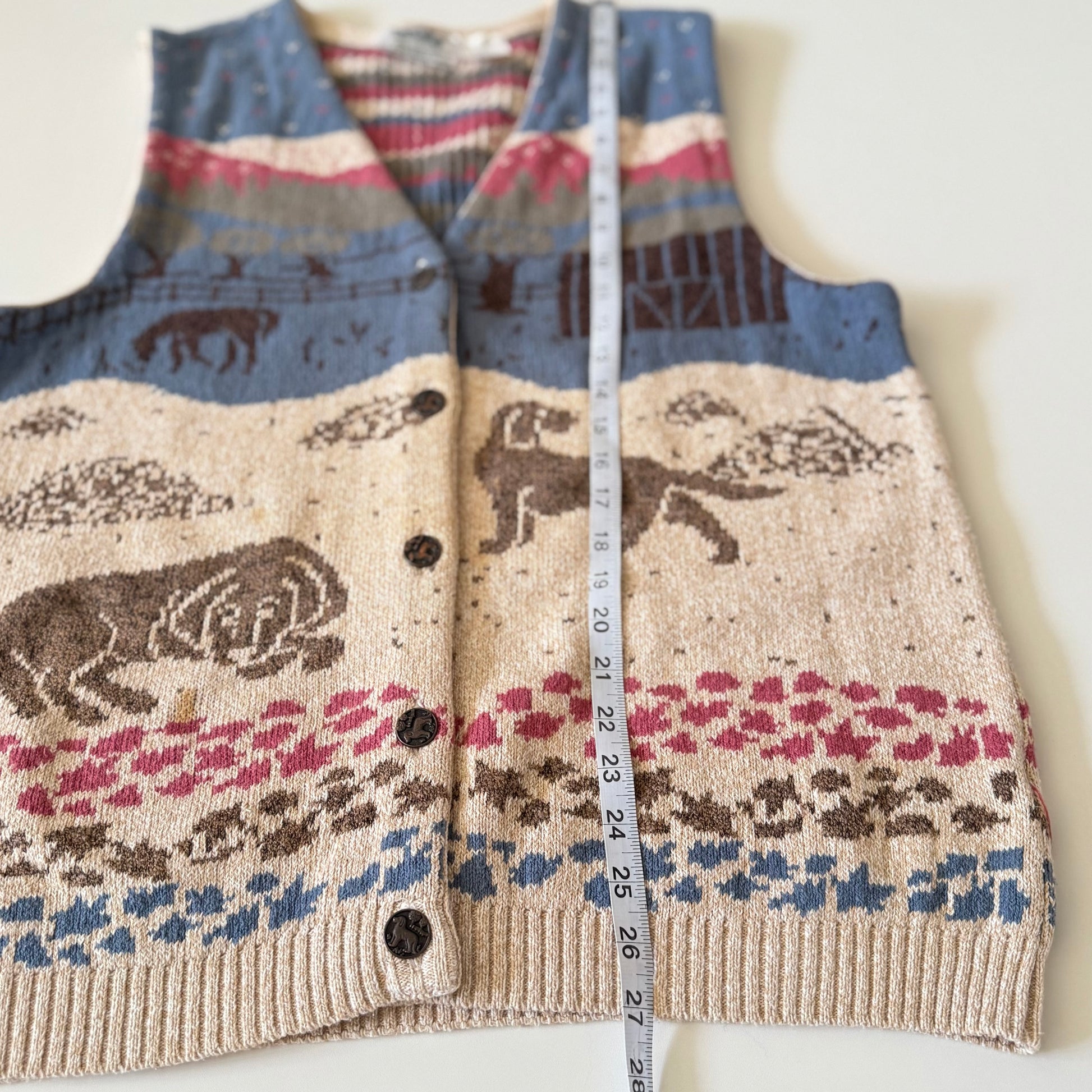 Knitted vest with animal pattern and measuring tape on a white background