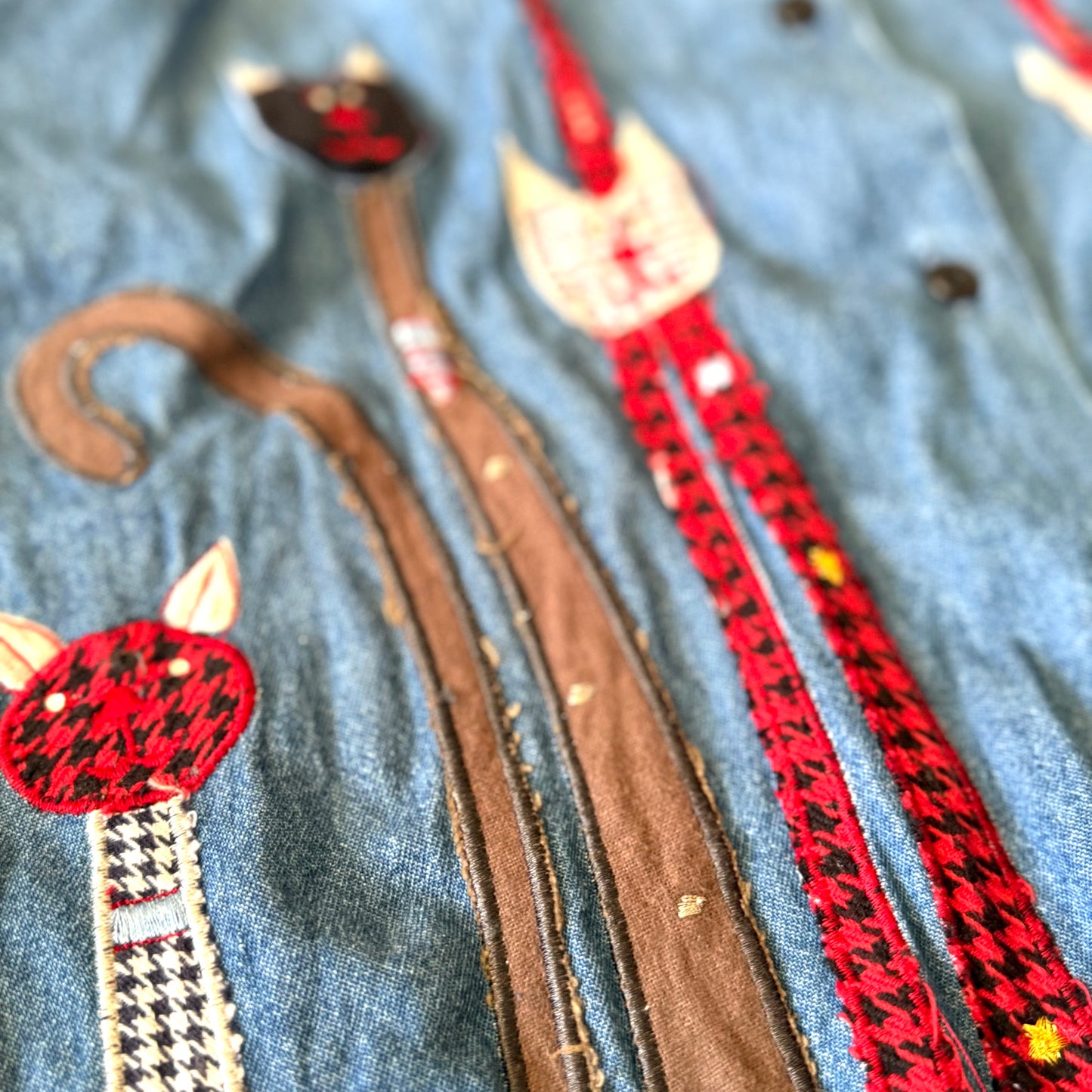 Cat-themed dog leashes with red and black patterns on a denim background