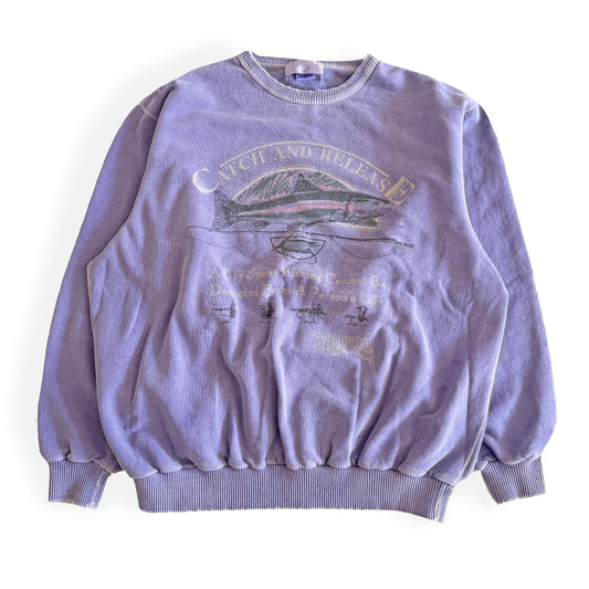 Light purple sweatshirt with fishing theme images and words on the front, on a white backdrop. 