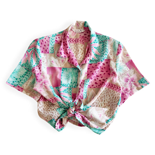 Button down bright coloured (tan, pink, teal) shirt with tropical and animal print patterns on it - placed on a white background. 