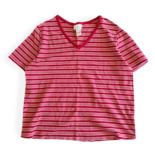 White, pink, and red striped t-shirt with a v-neck collar on a white backdrop. 