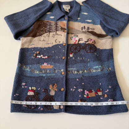 Blue embroidered jacket with a scenic design on a white background