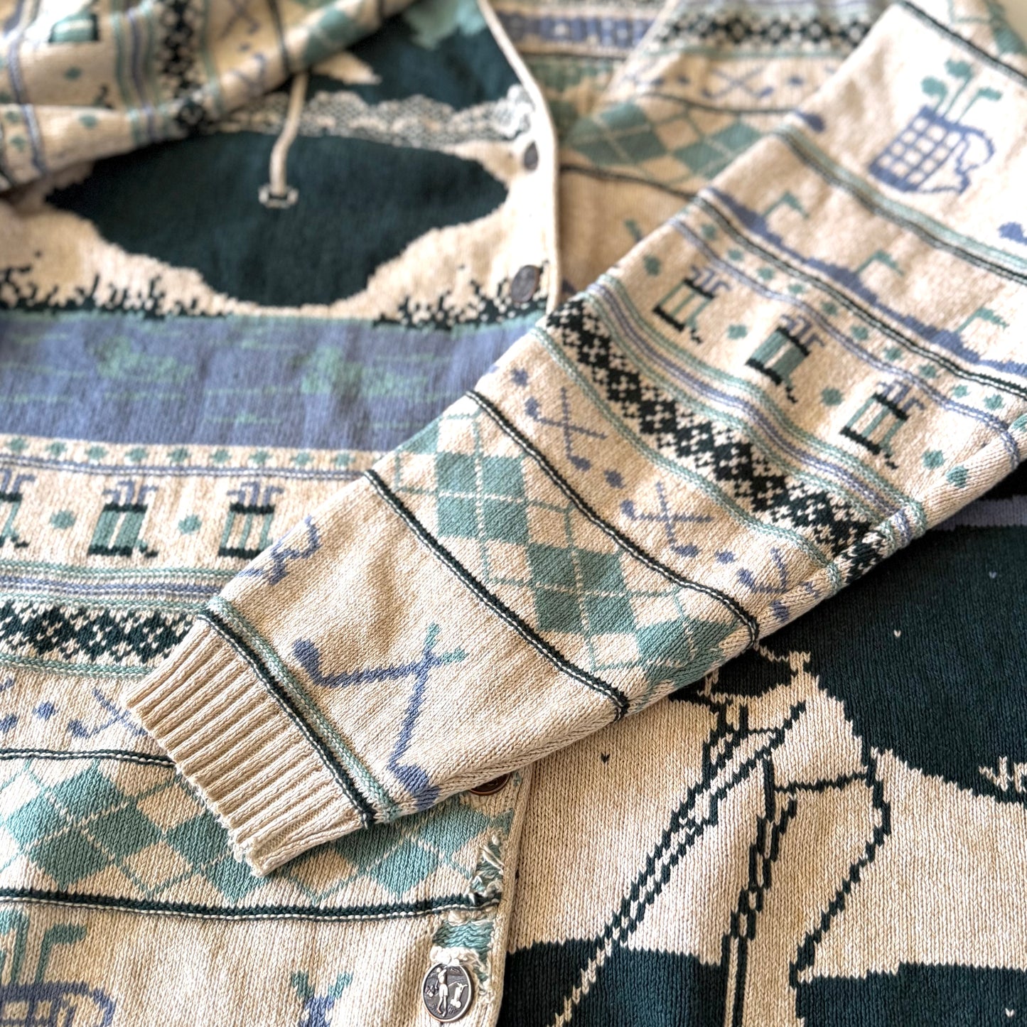 Golf themed sleeve of a cardigan. 