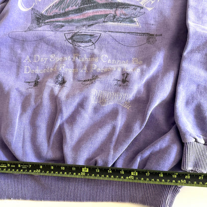 Light purple sweatshirt with fishing theme images and words on the front, on a white backdrop - with a measuring tape laid on it. 