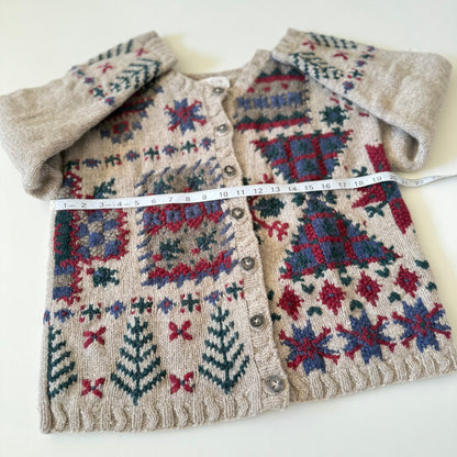 Knitted cardigan with geometric pattern and measuring tape on a white background