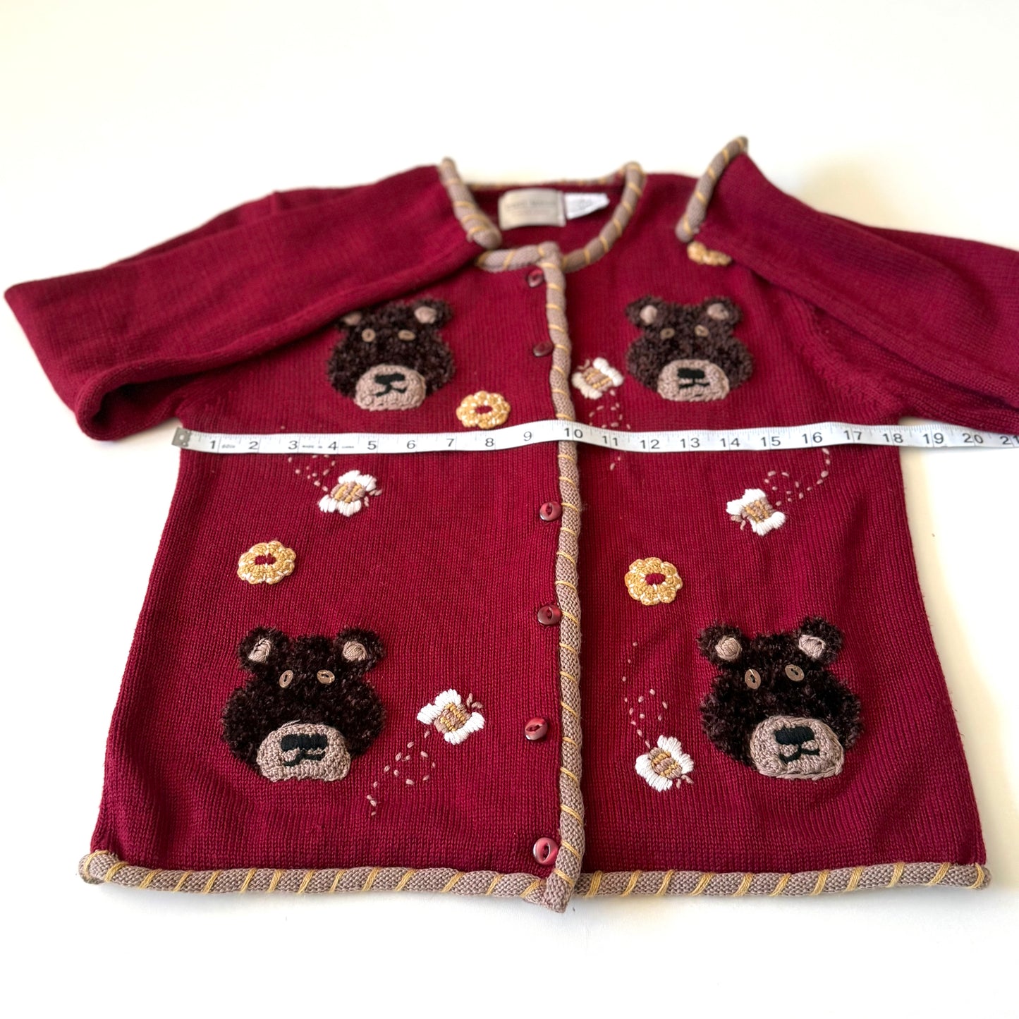 Bear cardigan with meausring tape on it. 