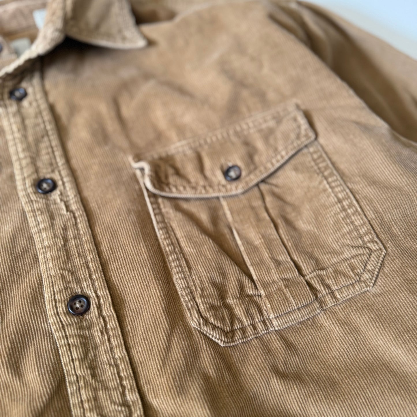 Close-up of a brown corduroy shirt with a pocket