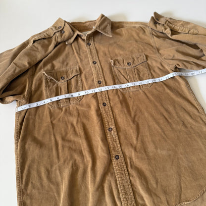 Brown shirt with a measuring tape laid across it on a white background