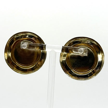 Pair of gold earrings with clear stones on a white background