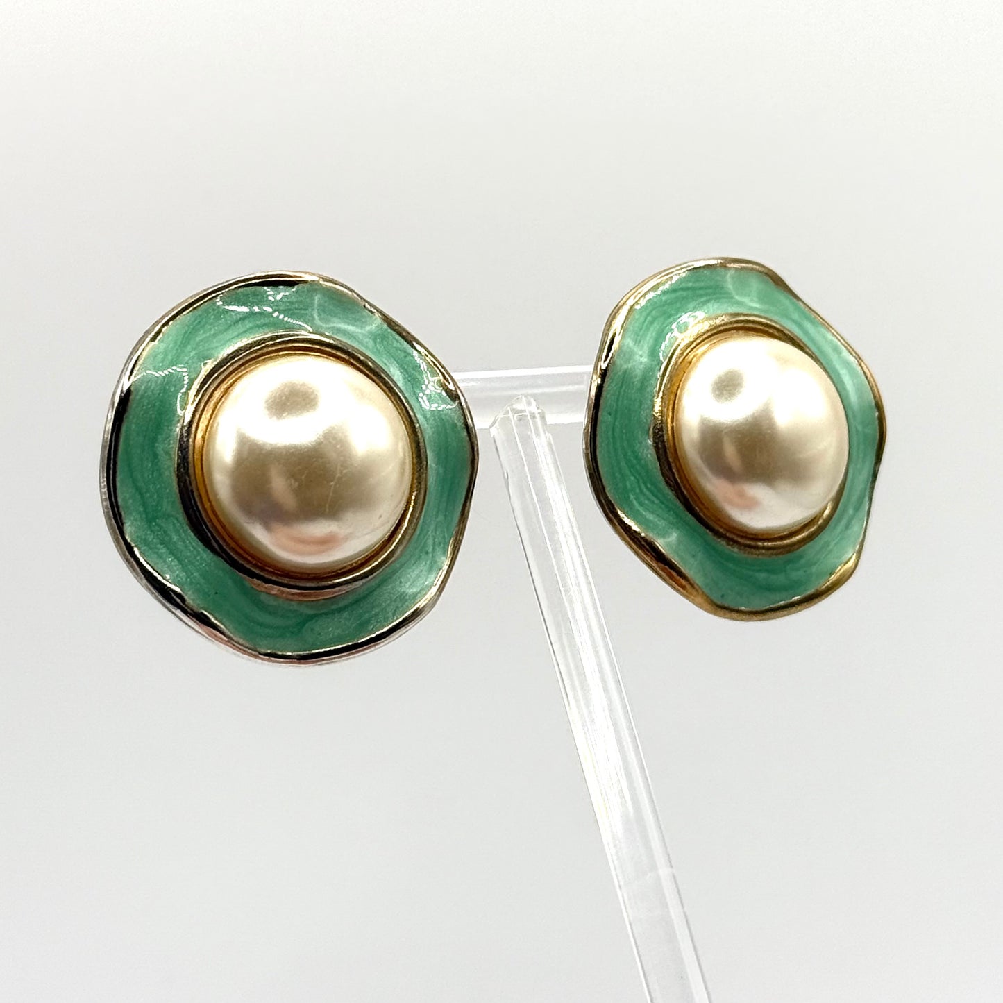 Pair of earrings with green and gold design on a white background