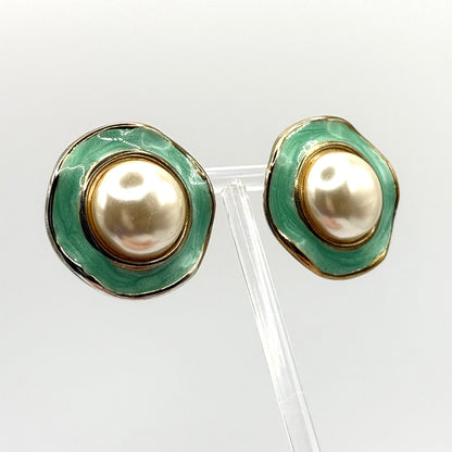 Pair of earrings with green and gold design on a white background