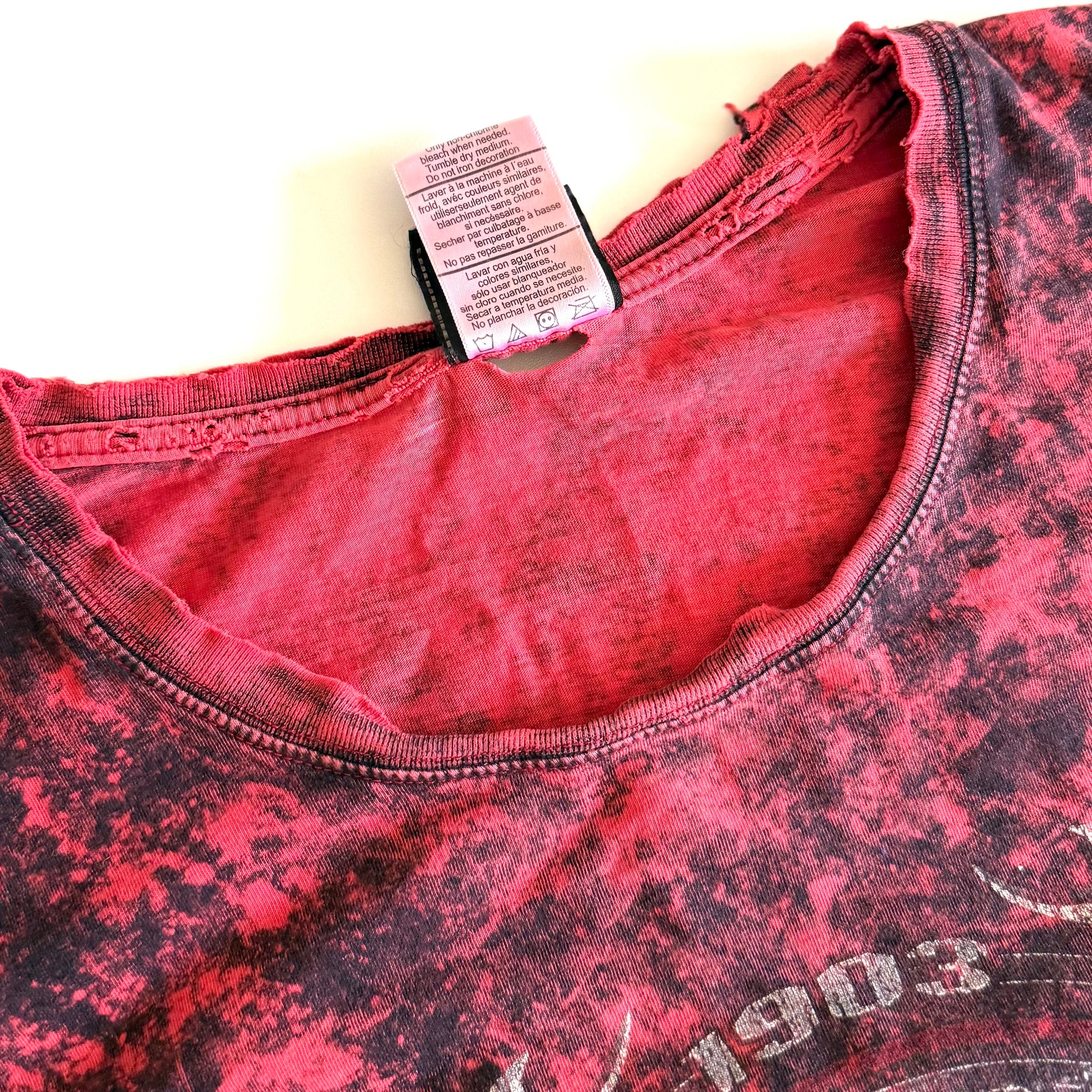 Distristed collar from Pinky red t-shirt with black ie dye effect, and the harley davidson logo on the front - on a white background. 