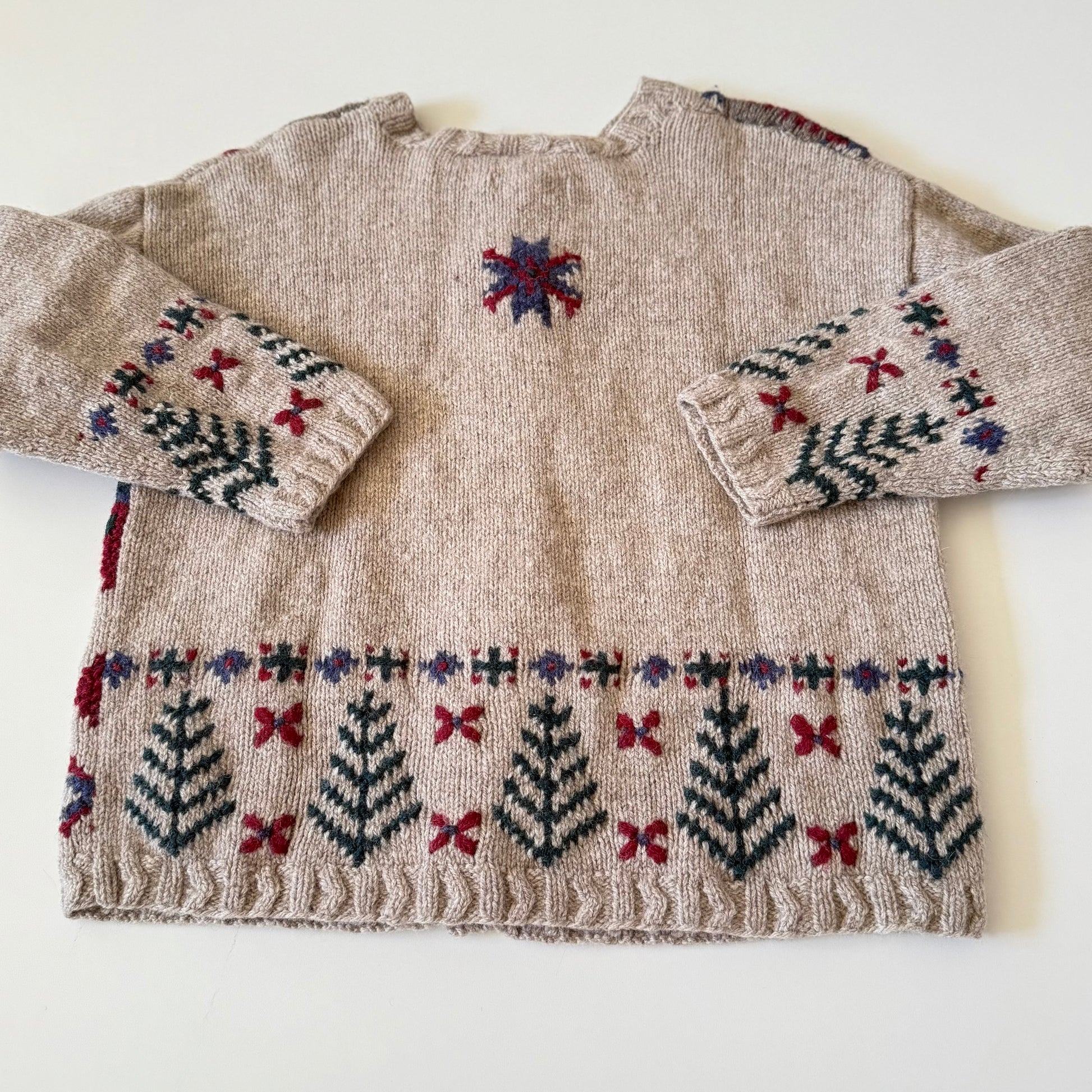 Knitted sweater with patterned sleeves on a white background