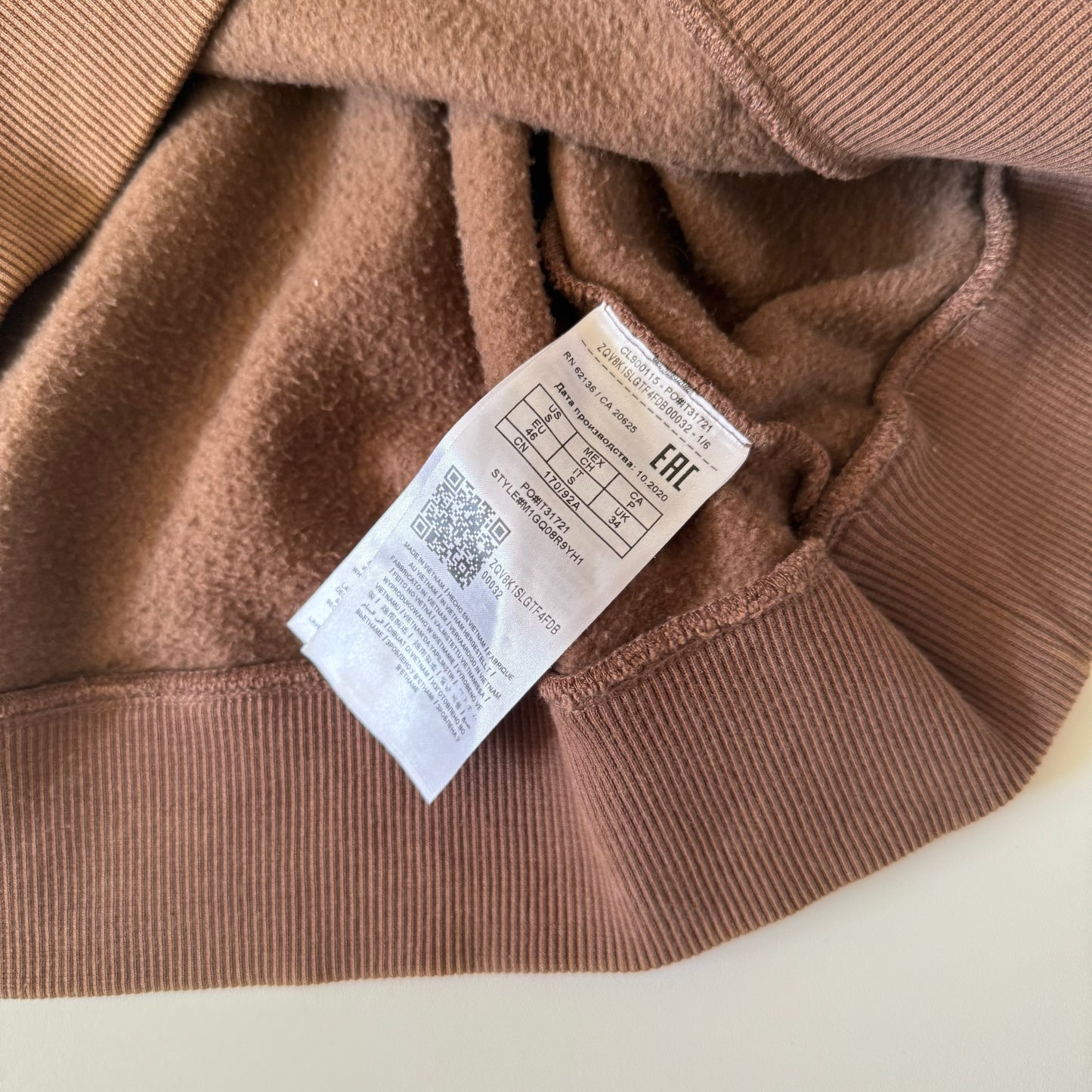 Close-up of a brown garment with a label on a white background