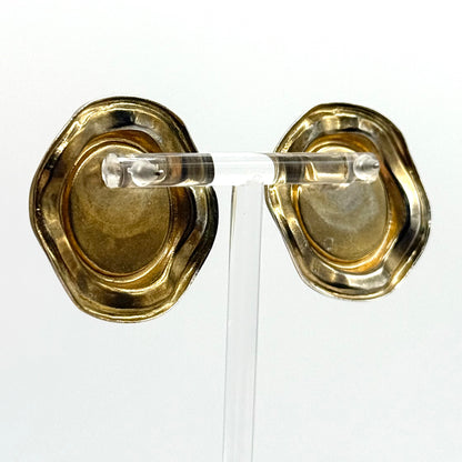 Gold earring with clear plastic backing on a white background