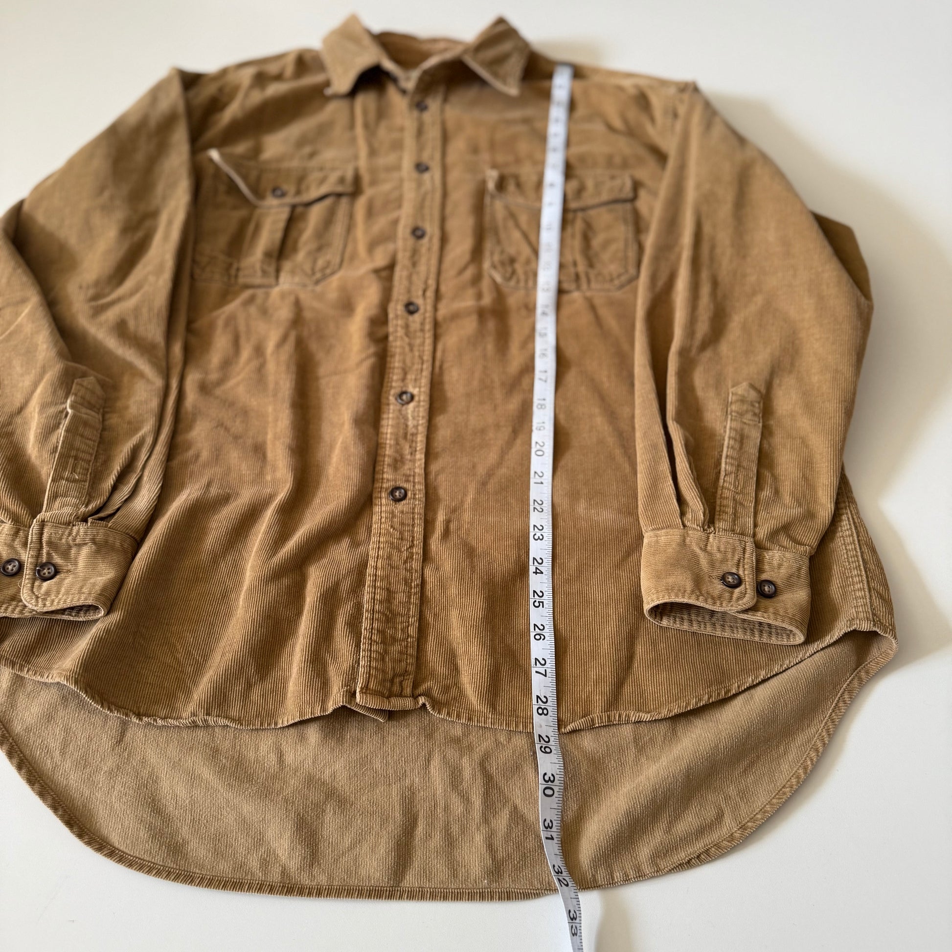 Brown shirt with a measuring tape on a white background