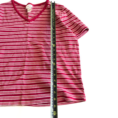 White, pink, and red striped t-shirt with a v-neck collar on a white backdrop - plus a measuring tape laid out on it. 