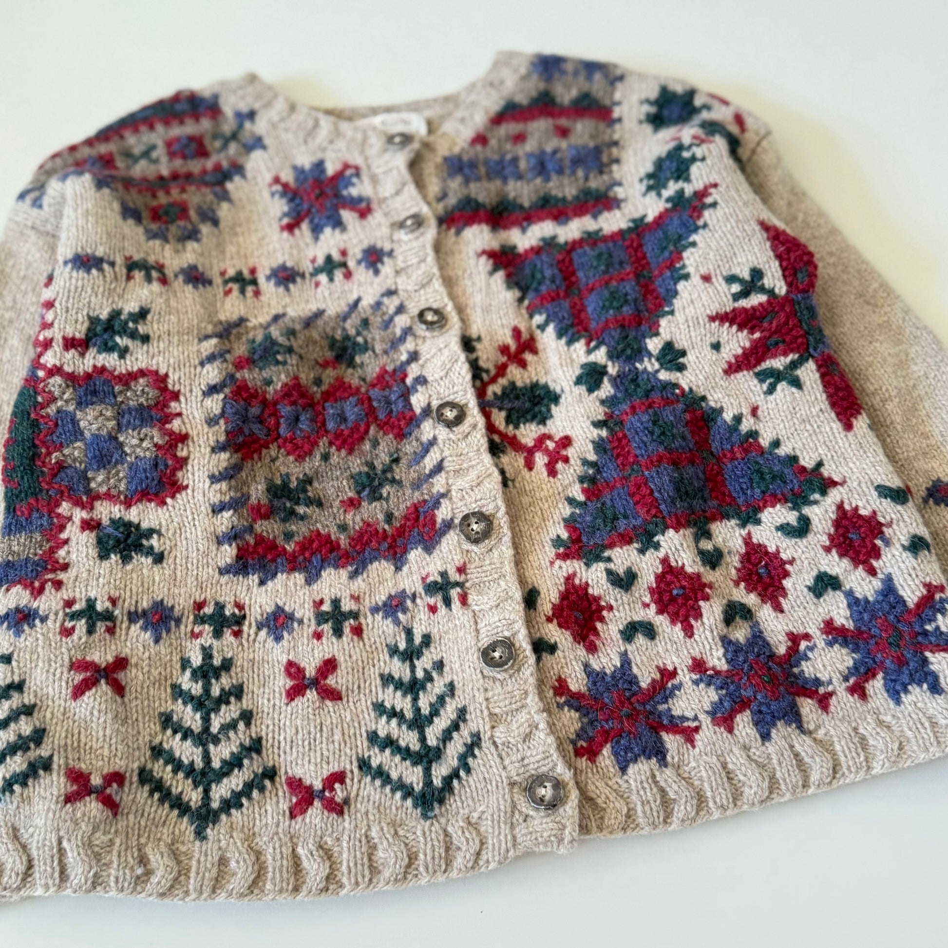 Knitted cardigan with colorful geometric pattern on a white background