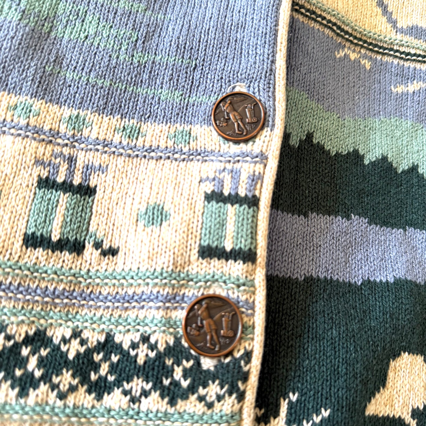 Golfing person on metal buttons, on the cardigan.