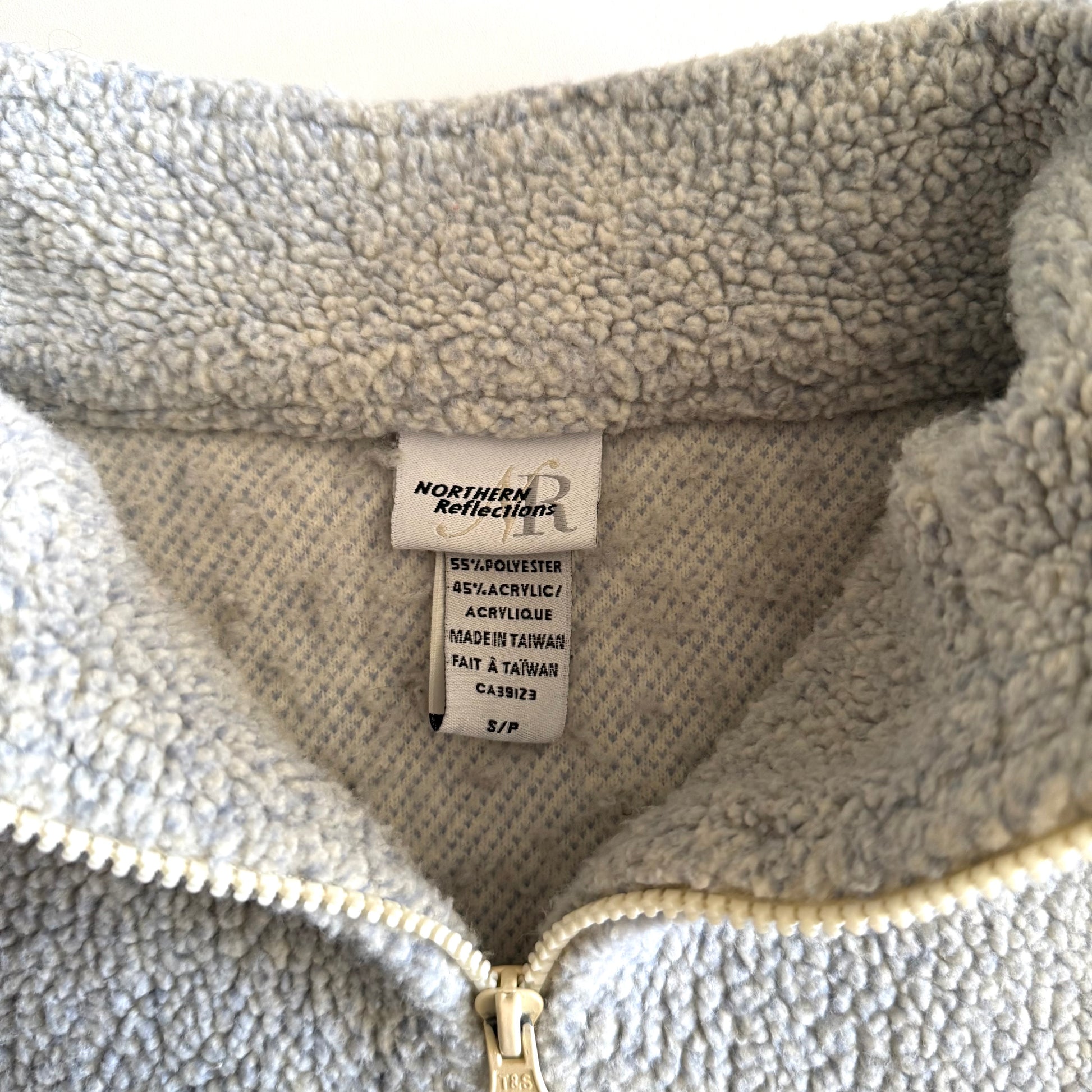 Tag of a Northern Reflections sweater, Size Small / 55% Polyester 45% Acrylic / Made in Taiwan. 