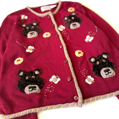 Red sweater with bear and flower patterns on a white background