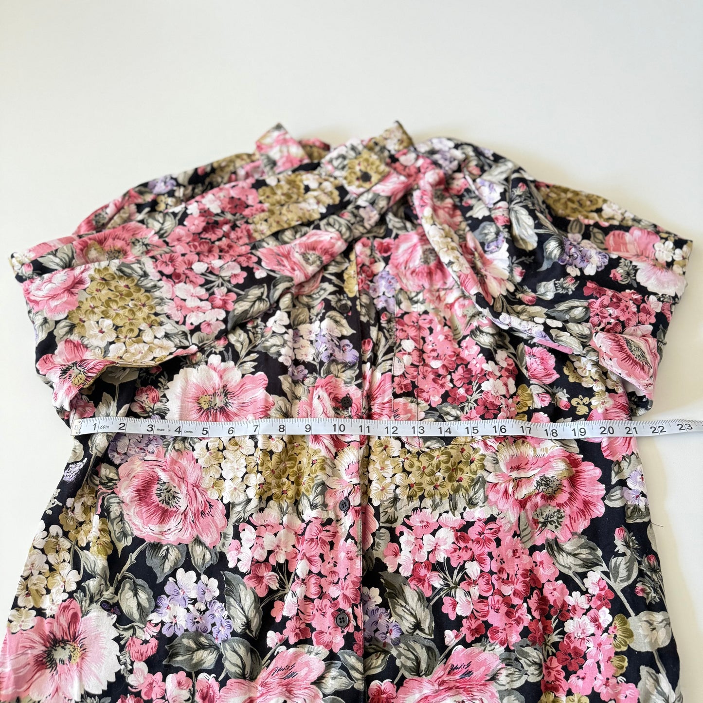 Floral patterned garment with a measuring tape on a white background