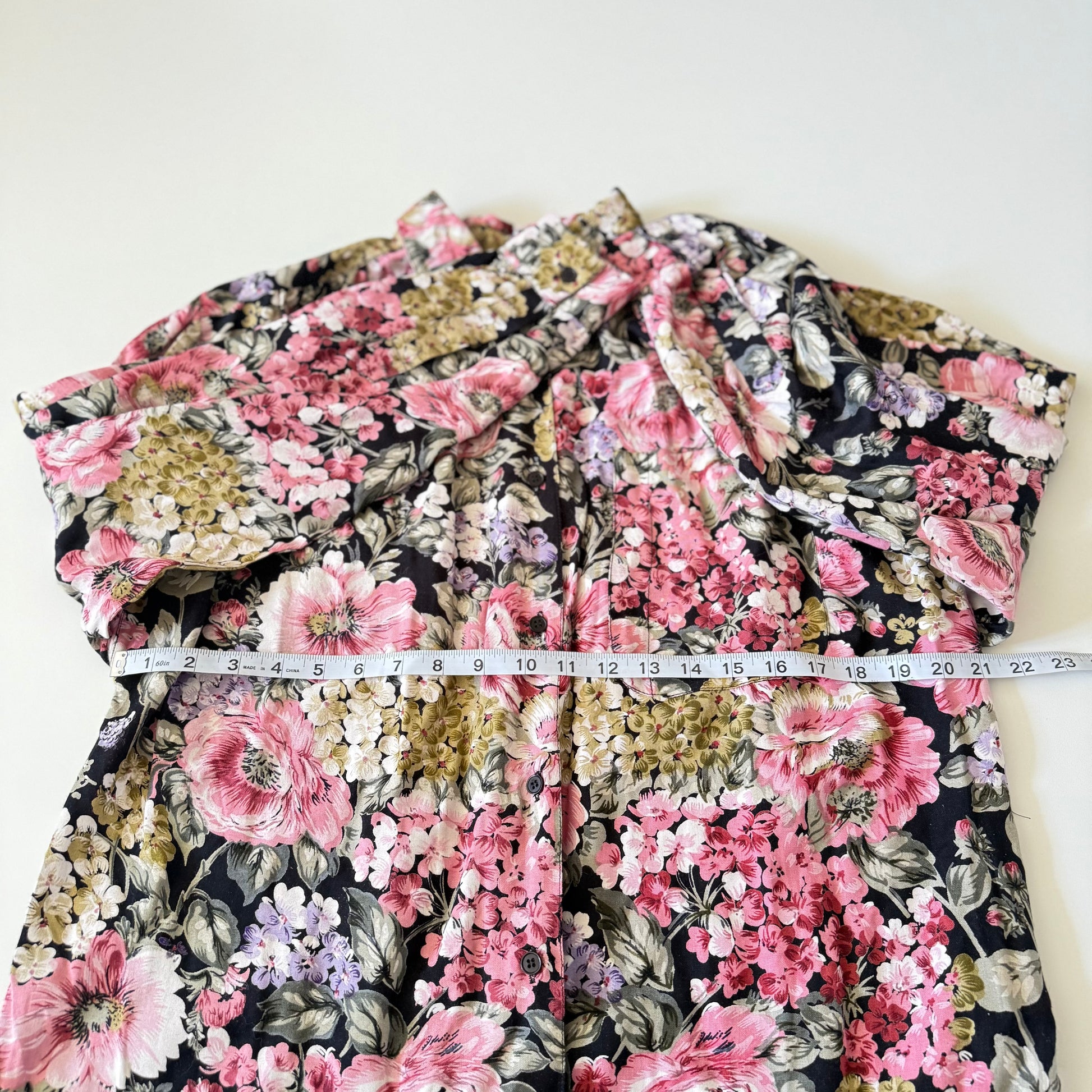 Floral patterned garment with a measuring tape on a white background