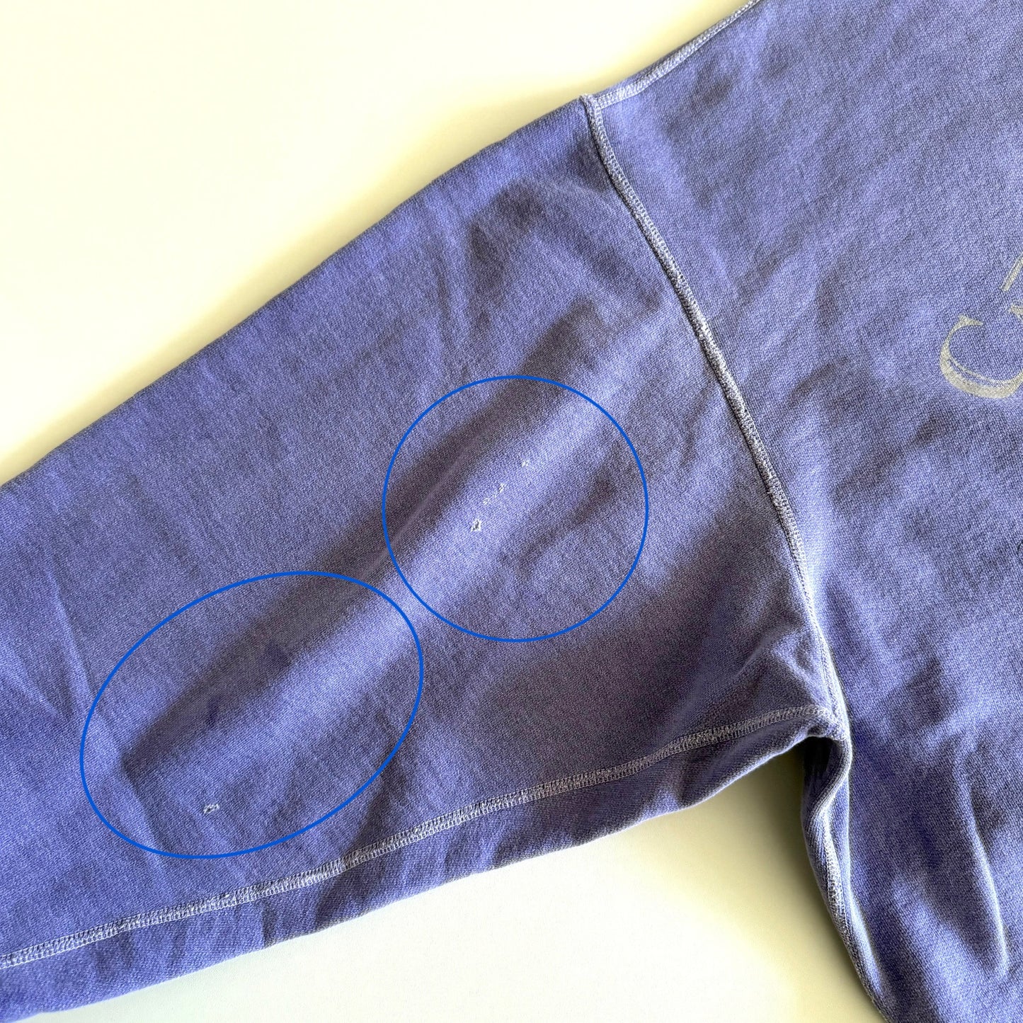 Circled flaws in sweatshirt on the arm. 