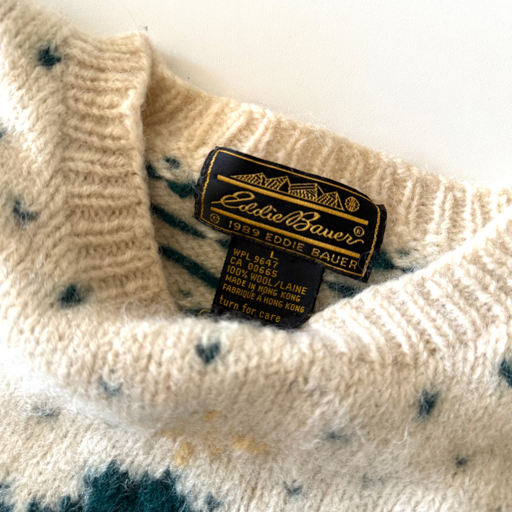 Close-up of a sweater with an Eddie Bauer label on a white background