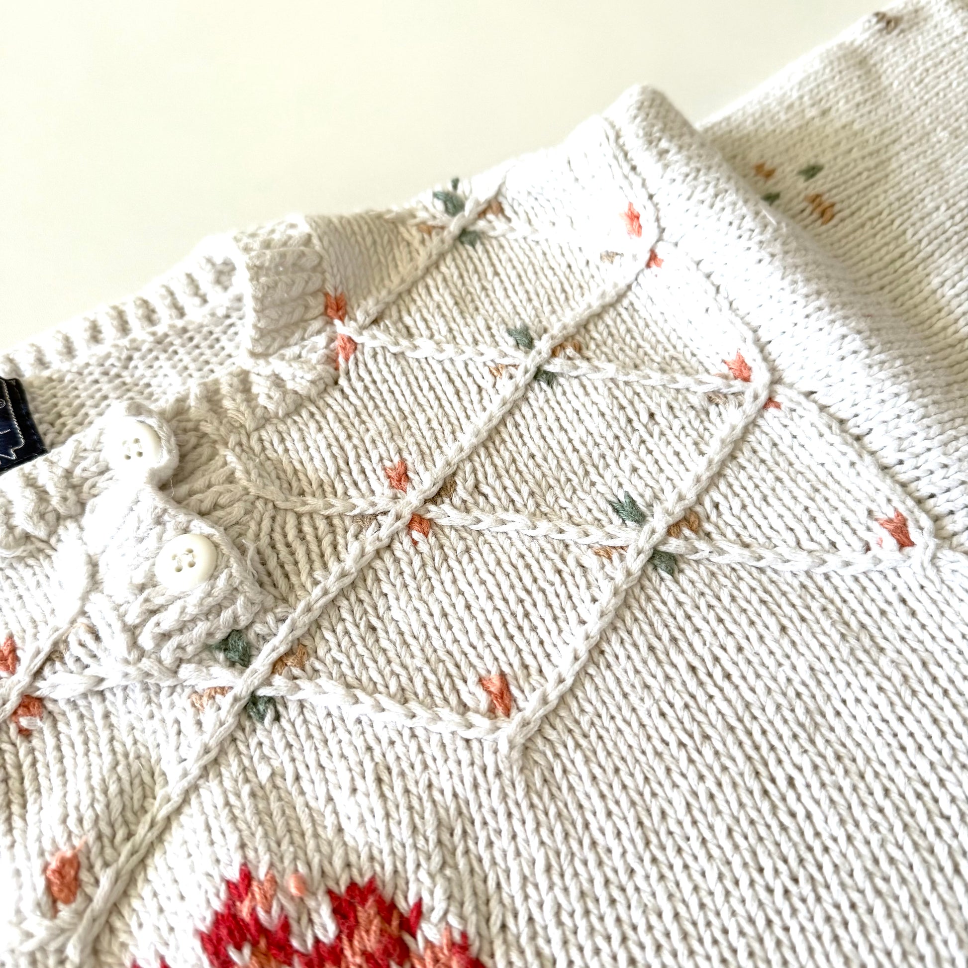 Close-up of a textured fabric with a diamond pattern and small floral details.