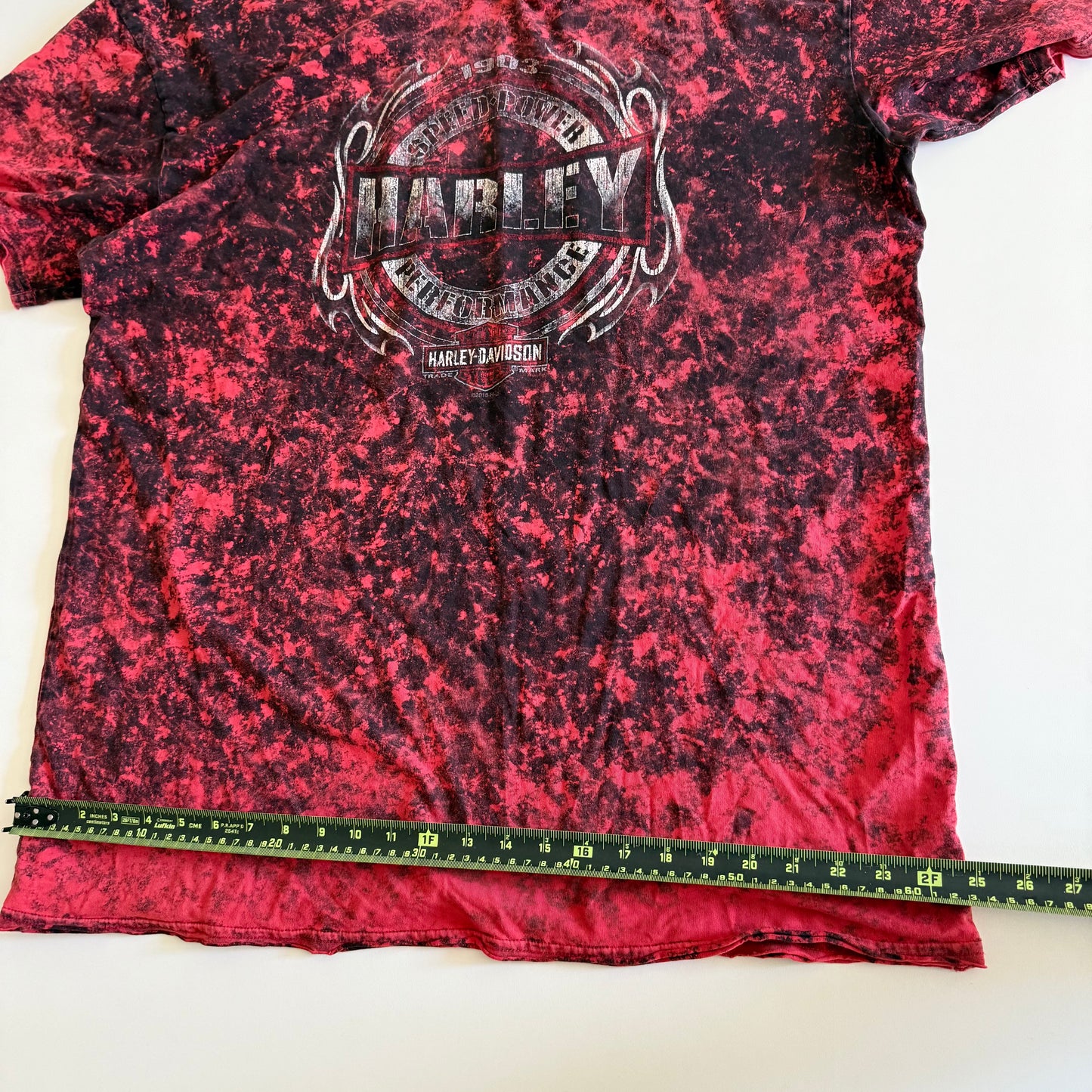 Pinky red t-shirt with black ie dye effect, and the harley davidson logo on the front - on a white background.  With a tape measure aid on it. 