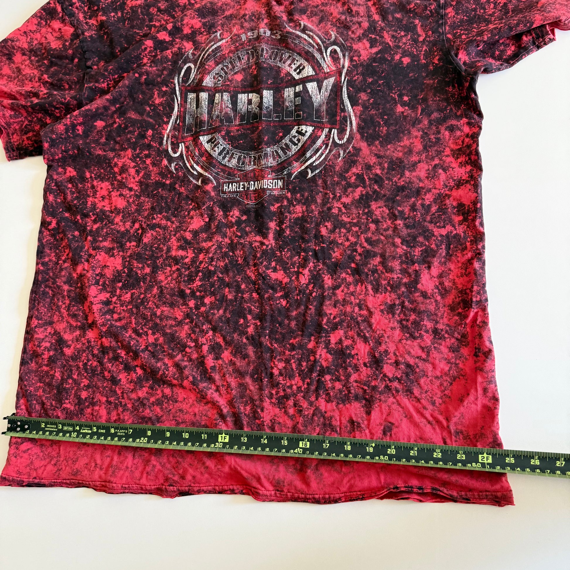 Pinky red t-shirt with black ie dye effect, and the harley davidson logo on the front - on a white background.  With a tape measure aid on it. 