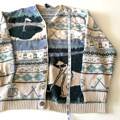 Golf themed cardigan with a white backdrop with a measuring tape on it. 