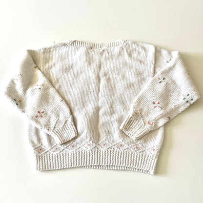 Knitted sweater with floral patterns on a white background