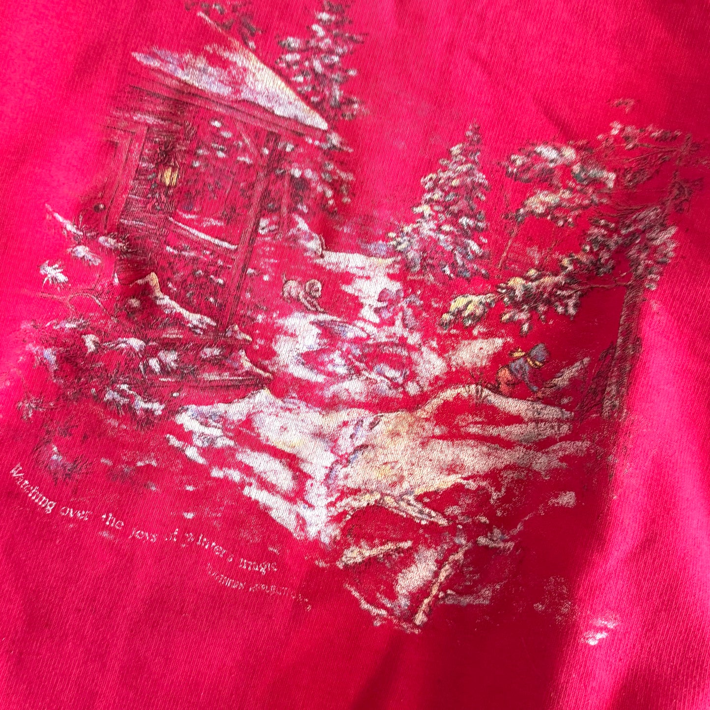 Bold pink sweatshirt / crewneck with a winter scene on the front  - close up of the scene with a kid, dog, snow covered forest, and cabin.