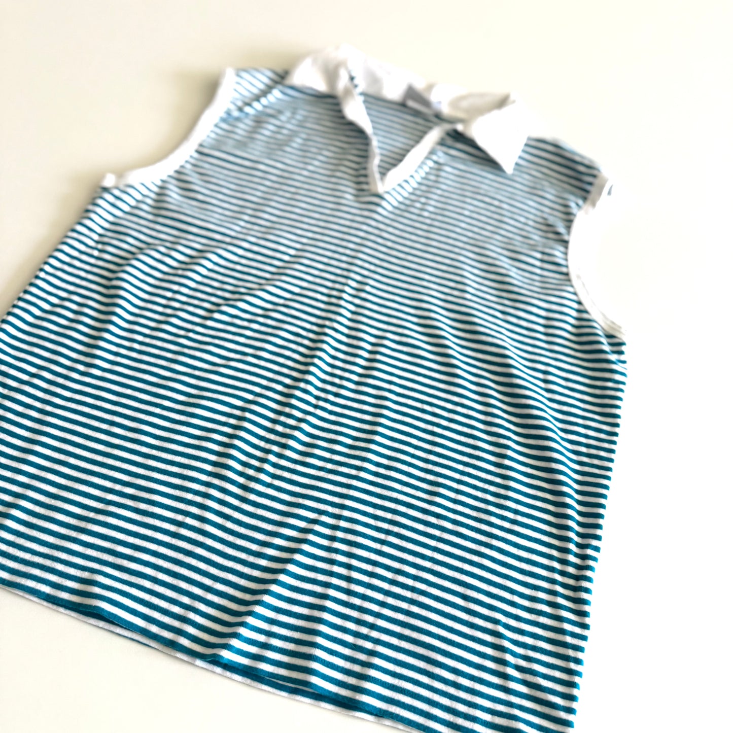 White and turquoise striped tank top with polo neckline, on a white backdrop. 