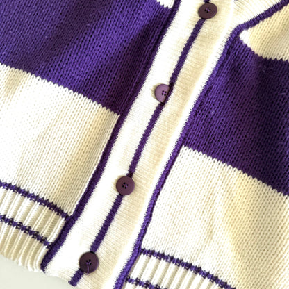 Close up of buttons on a purple and white striped cardigan. 